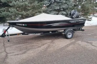 Slide: The Image of 2013 Crestliner 1650 Fish Hawk boat on trailer, covered, with Mercury outboard motor. - 1