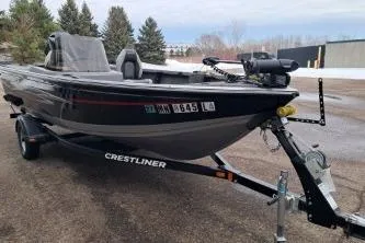 Slide: The Image of 2013 Crestliner 1650 Fish Hawk boat on trailer, covered, parked on snowy driveway. - 2