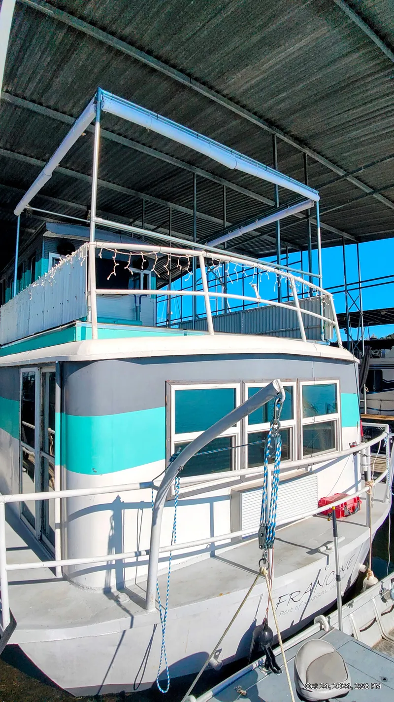 Slide: The Image of 1964 Kelly 62' houseboat docked, painted in blue and white. - 4