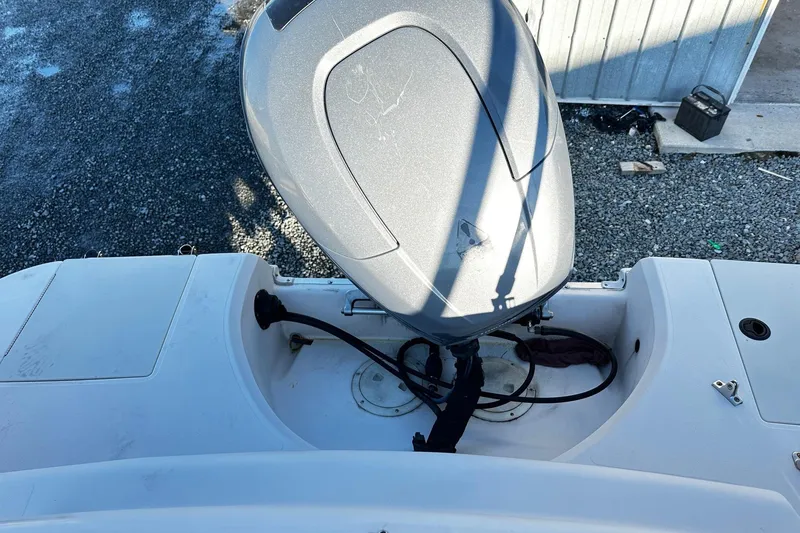 Slide: The Image of 2002 Godfrey Hurricane 237 boat with outboard motor, docked on gravel surface. - 12