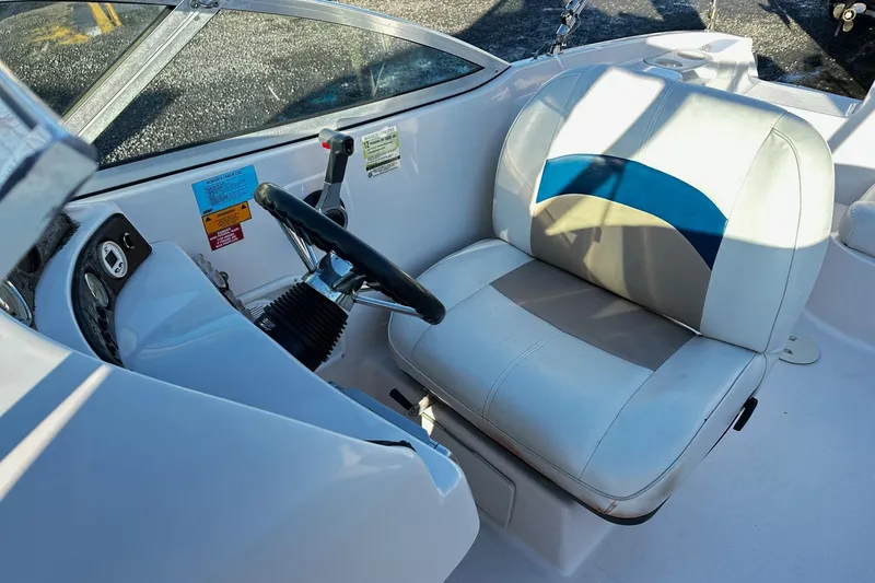Slide: The Image of 2002 Godfrey Hurricane 237 boat cockpit with steering wheel and cushioned seat. - 4