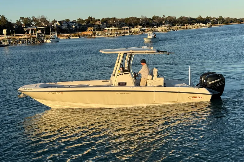 Slide: The Image of 2016 Boston Whaler 270 Dauntless boat on calm water, with scenic background. - 0