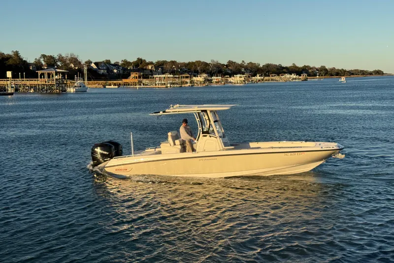 Slide: The Image of 2016 Boston Whaler 270 Dauntless boat cruising on a calm waterway at sunset. - 10