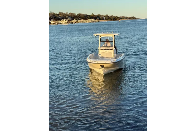 Slide: The Image of 2016 Boston Whaler 270 Dauntless boat cruising on a calm lake at sunset. - 11