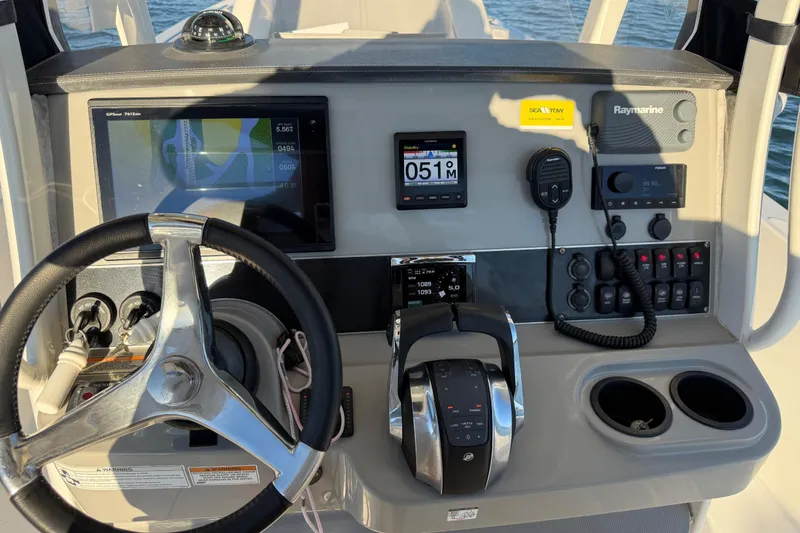 Slide: The Image of Control panel of a 2016 Boston Whaler 270 Dauntless boat with steering wheel and navigation instruments. - 17