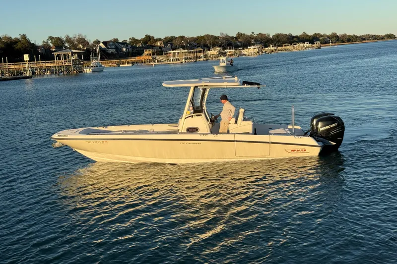 Slide: The Image of 2016 Boston Whaler 270 Dauntless boat cruising on a calm waterway. - 2