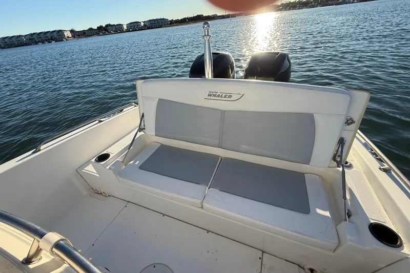 Slide: The Image of 2016 Boston Whaler 270 Dauntless boat interior with seating and twin engines on water. - 28