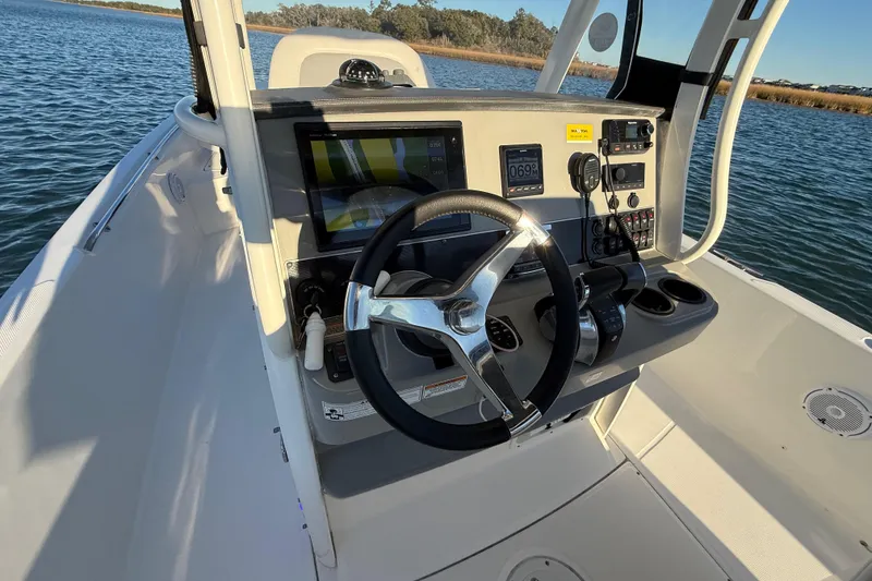 Slide: The Image of 2016 Boston Whaler 270 Dauntless boat helm with steering wheel and navigation controls. - 29