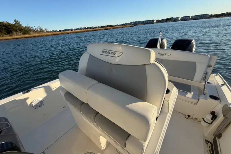 Slide: The Image of 2016 Boston Whaler 270 Dauntless boat interior with dual engines on a calm lake. - 36