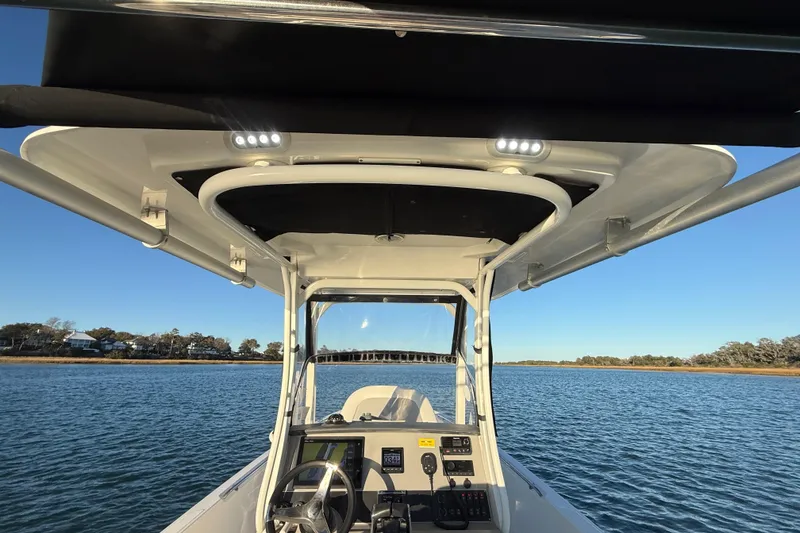 Slide: The Image of 2016 Boston Whaler 270 Dauntless boat console with canopy on calm water. - 38