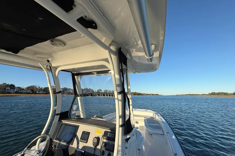 Slide: The Image of 2016 Boston Whaler 270 Dauntless on calm water, clear sky, coastal view. - 42