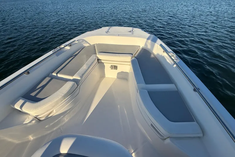 Slide: The Image of 2016 Boston Whaler 270 Dauntless boat interior with cushioned seating on calm water. - 43