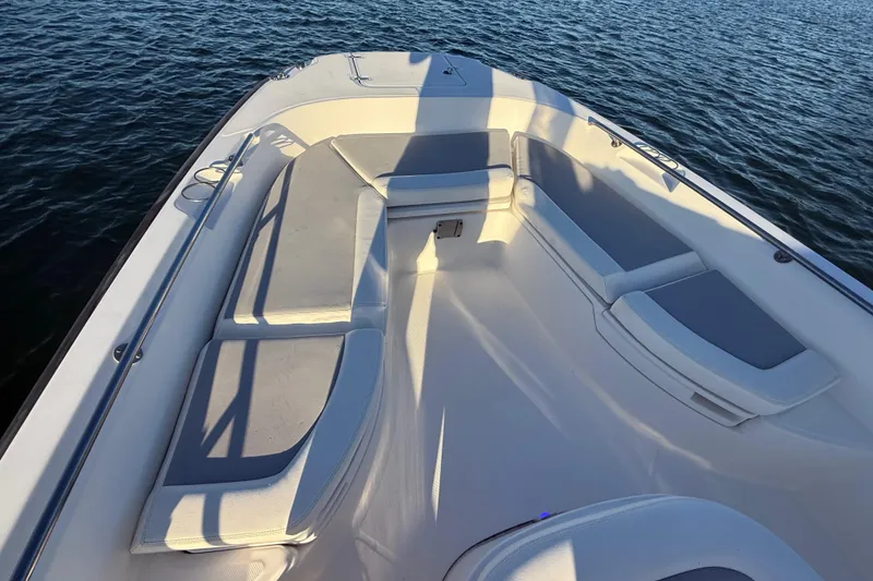 Slide: The Image of 2016 Boston Whaler 270 Dauntless boat interior with cushioned seating on calm water. - 45