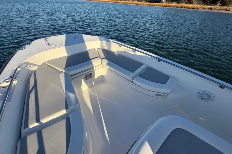 Slide: The Image of 2016 Boston Whaler 270 Dauntless boat interior with cushioned seating on calm water. - 46