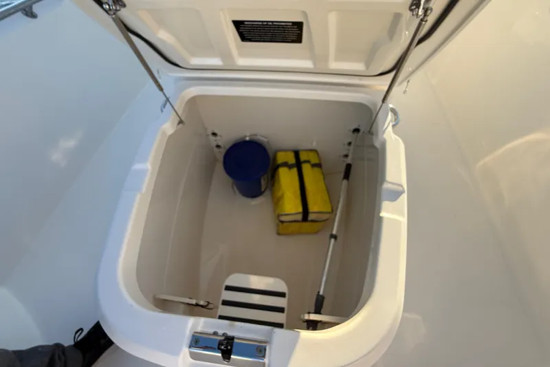 Slide: The Image of Open storage compartment on 2016 Boston Whaler 270 Dauntless boat with equipment inside. - 48