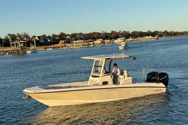 Slide: The Image of 2016 Boston Whaler 270 Dauntless boat cruising on a scenic waterway. - 5