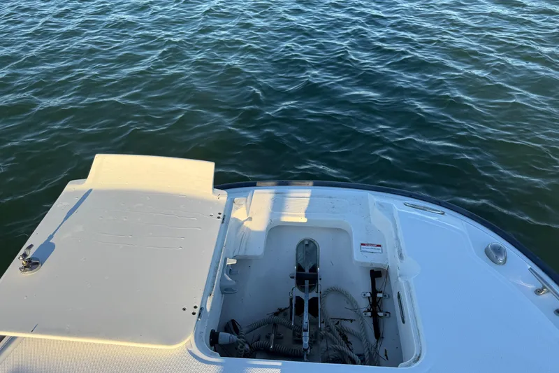 Slide: The Image of 2016 Boston Whaler 270 Dauntless boat deck with anchor storage, on calm water. - 58