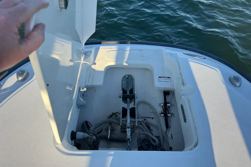 Slide: The Image of 2016 Boston Whaler 270 Dauntless anchor storage compartment with ropes, open on calm water. - 60