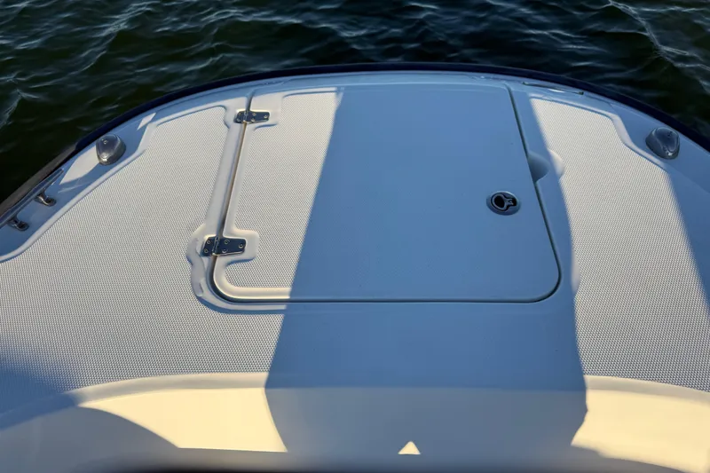 Slide: The Image of 2016 Boston Whaler 270 Dauntless boat deck with storage hatch, on calm water. - 61