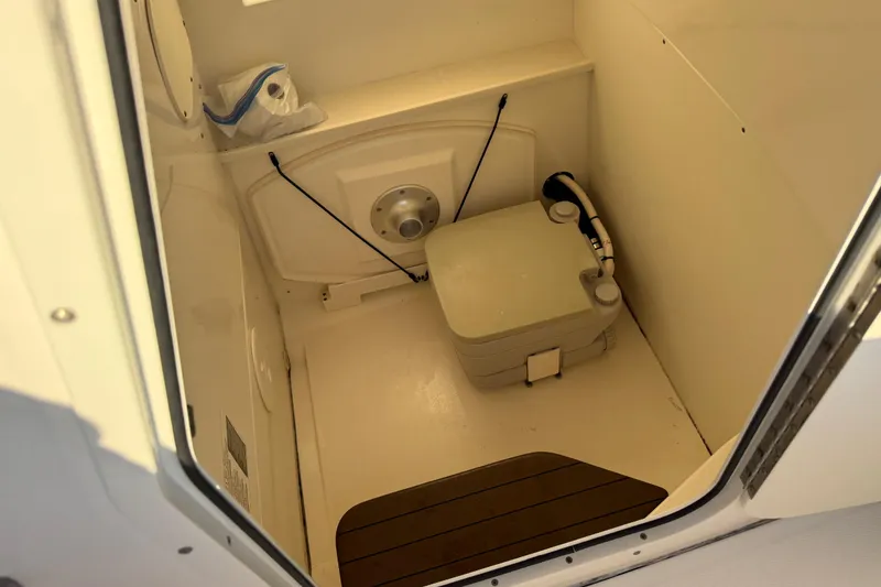 Slide: The Image of Interior of 2016 Boston Whaler 270 Dauntless boat with compact toilet setup. - 62