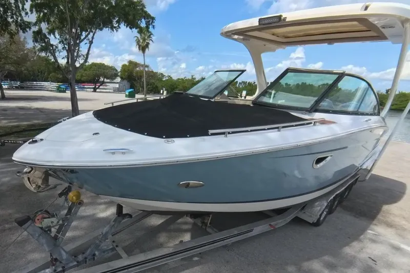Slide: The Image of 2018 Regal 29 OBX boat on trailer, parked outdoors under clear sky. - 19