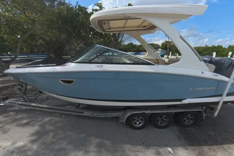 Slide: The Image of 2018 Regal 29 OBX boat on trailer, parked outdoors under a clear sky. - 22