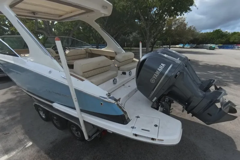 Slide: The Image of 2018 Regal 29 OBX boat with Yamaha outboard motor, parked on a trailer. - 24
