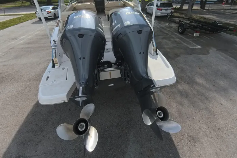 Slide: The Image of 2018 Regal 29 OBX boat with dual outboard engines in a parking area. - 25