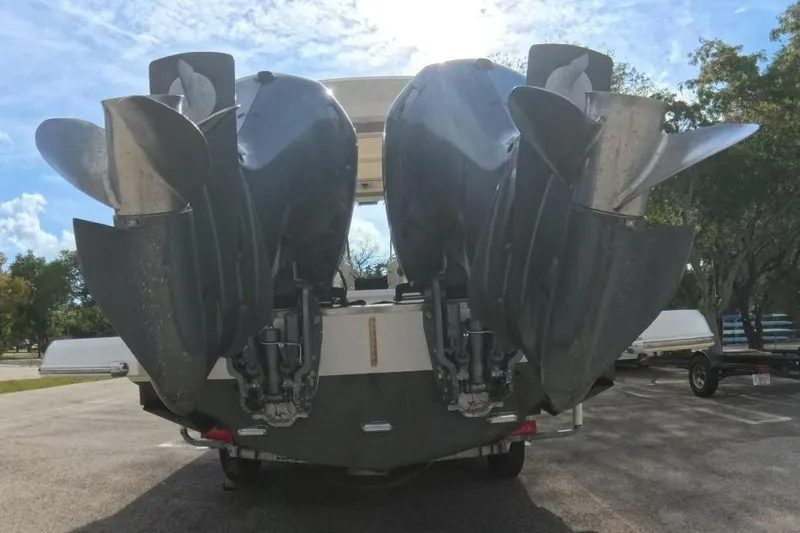 Slide: The Image of 2018 Regal 29 OBX boat with dual outboard engines in a sunny parking lot. - 26