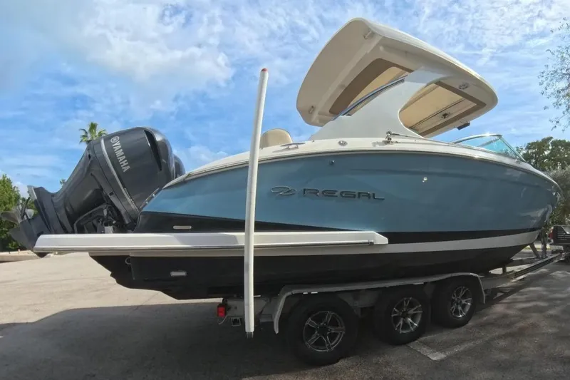 Slide: The Image of 2018 Regal 29 OBX boat on trailer, parked outdoors, with Yamaha outboard motor. - 28