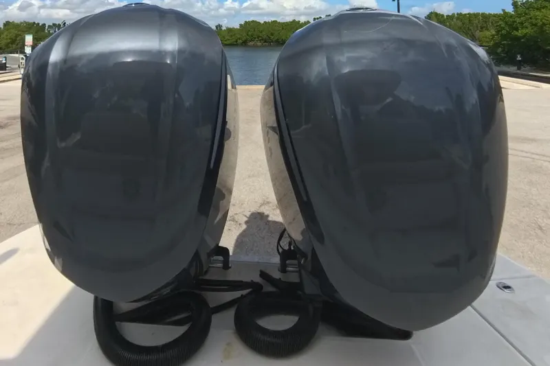 Slide: The Image of 2018 Regal 29 OBX boat with dual outboard motors at a sunny dock. - 32