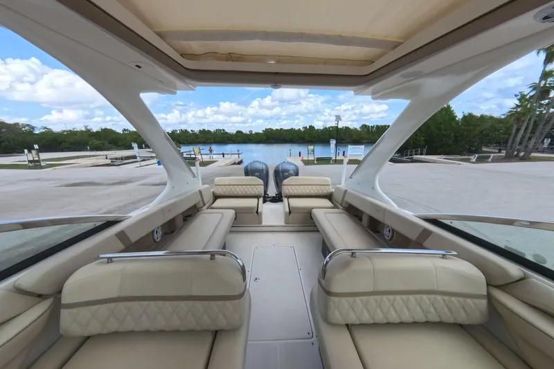 Slide: The Image of 2018 Regal 29 OBX boat interior with luxurious seating, docked by a scenic waterfront. - 40