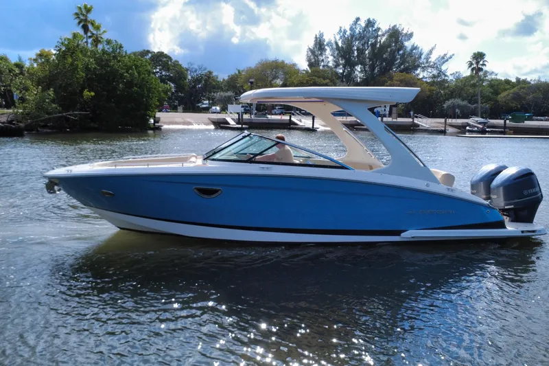 Slide: The Image of 2018 Regal 29 OBX boat on water, blue hull, dual Yamaha engines, scenic background. - 5