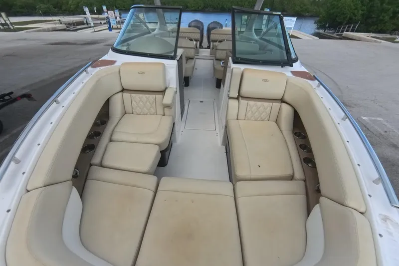 Slide: The Image of 2018 Regal 29 OBX boat interior with beige seating and cup holders, docked near water. - 50