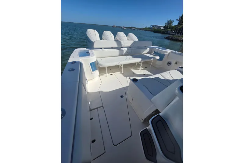 Slide: The Image of 2024 SeaVee 420Z boat interior with seating, on calm water, under clear blue sky. - 4