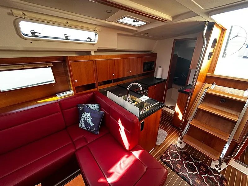 Slide: The Image of Interior of a 2016 Hanse 455 yacht with red sofa and kitchen. - 15