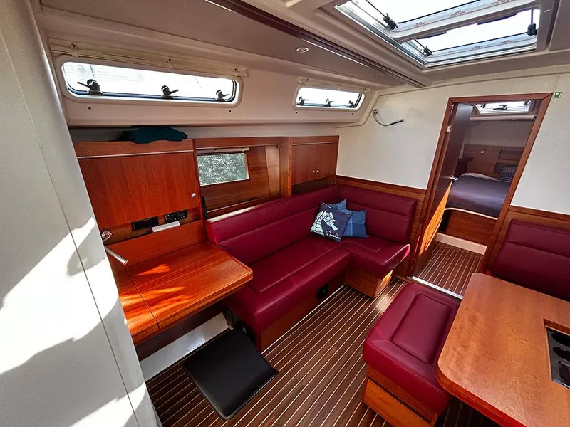 Slide: The Image of Interior of a 2016 Hanse 455 yacht with red sofa and wooden furnishings. - 21