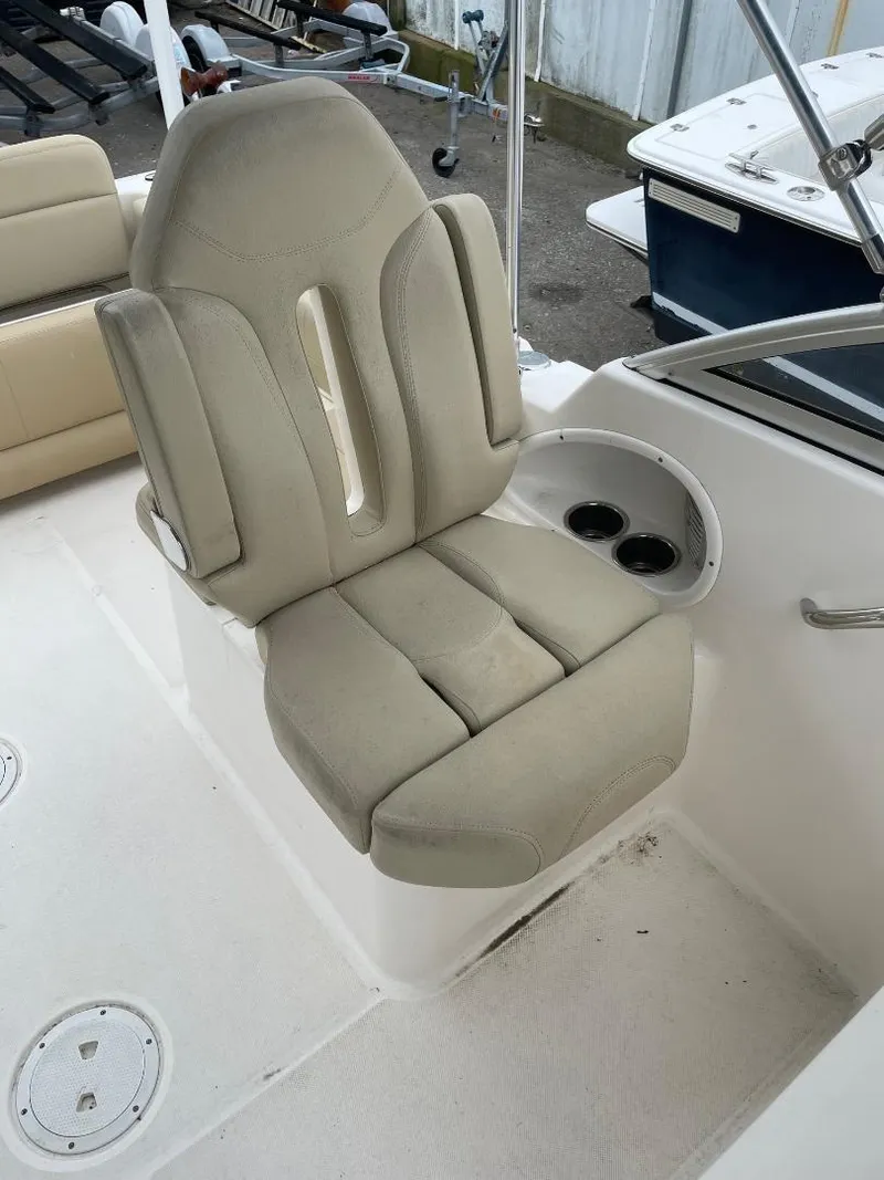 Slide: The Image of 2016 Pursuit DC 235 Dual Console boat seat with cup holders and beige upholstery. - 12