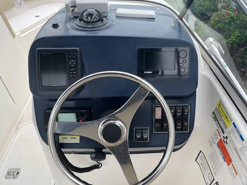 Slide: The Image of 2016 Pursuit DC 235 Dual Console dashboard with steering wheel, compass, and electronic displays. - 13