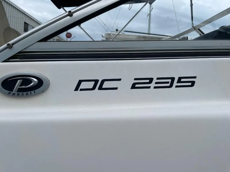 Slide: The Image of 2016 Pursuit DC 235 Dual Console boat logo and model name on hull. - 21