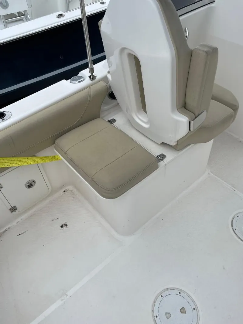 Slide: The Image of 2016 Pursuit DC 235 Dual Console boat seating area with beige cushions. - 6