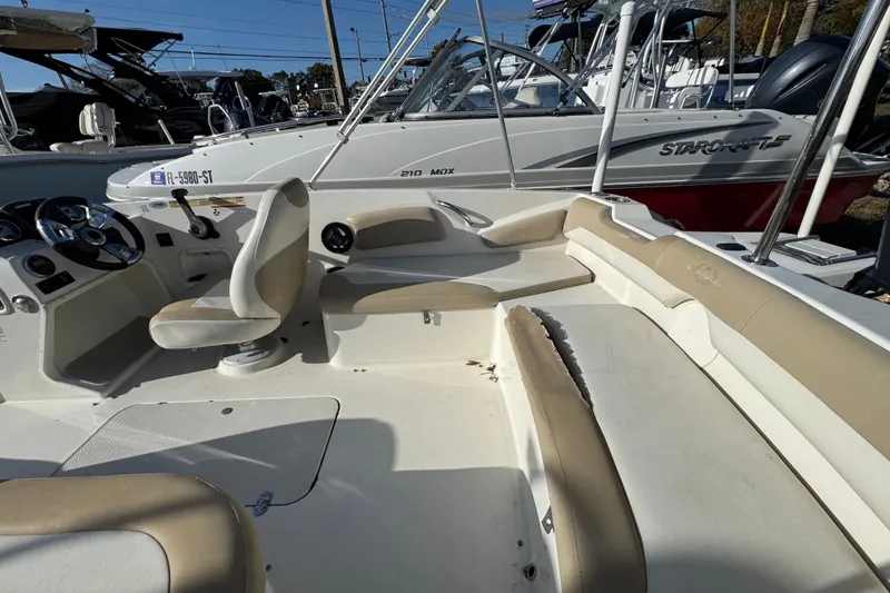 Slide: The Image of 2016 Stingray 182 SC boat interior with beige seating and steering console. - 12