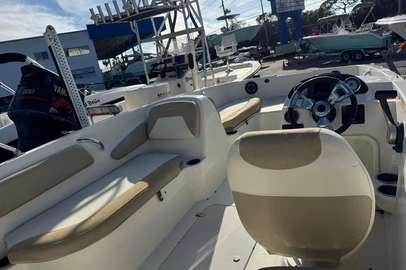 Slide: The Image of 2016 Stingray 182 SC boat interior with steering wheel and seating area. - 4