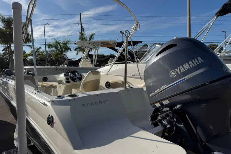 Slide: The Image of 2016 Stingray 182 SC boat with Yamaha engine, parked outdoors under clear sky. - 7