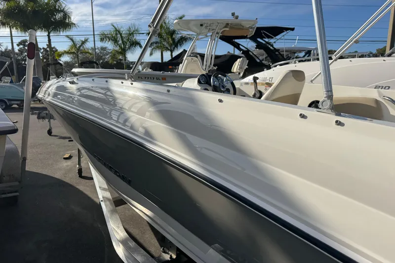 Slide: The Image of 2016 Stingray 182 SC boat in marina, sleek design, sunny day, palm trees in background. - 8