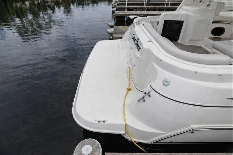 Slide: The Image of 2004 Cruisers Yachts 3372 Express docked, showing rear deck and water reflection. - 2