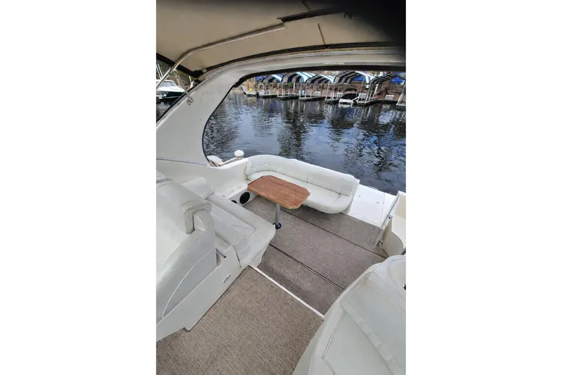 Slide: The Image of 2004 Cruisers Yachts 3372 Express interior with seating and table, dockside view. - 3