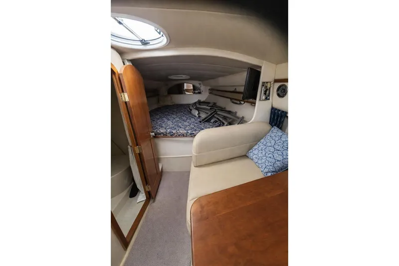 Slide: The Image of 2004 Cruisers Yachts 3372 Express cabin interior with bed, seating, and wooden accents. - 4