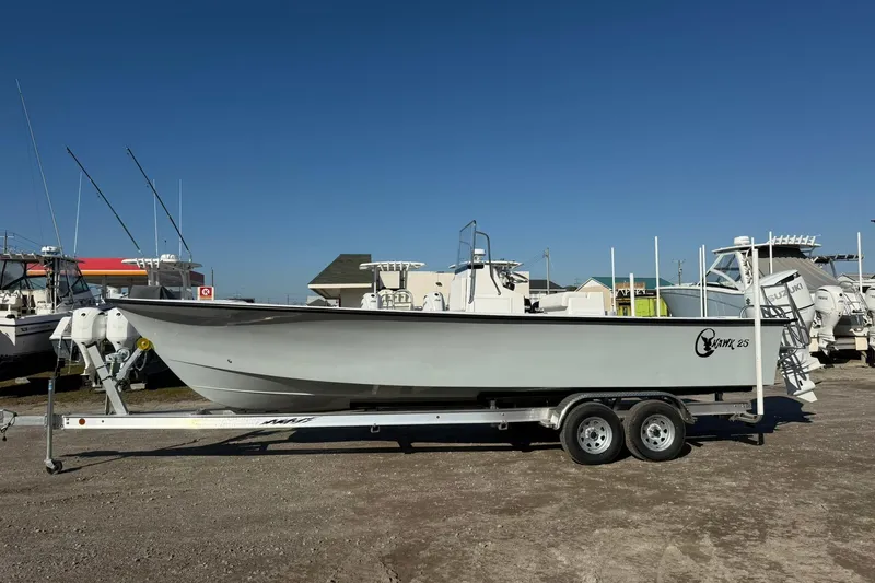 Slide: The Image of 2026 C-Hawk 25 Center Console boat on trailer at marina. - 2