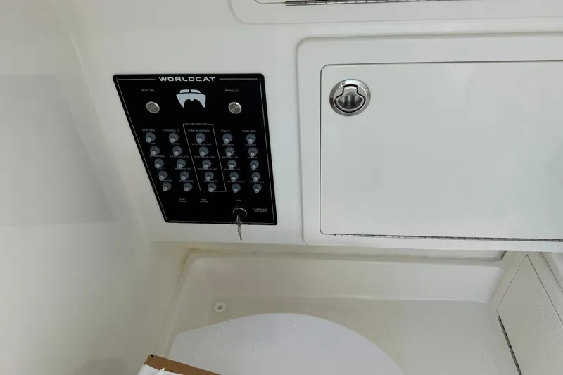 Slide: The Image of Control panel of 2026 World Cat 280 CC-X boat with switches and storage compartment. - 22